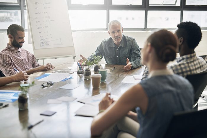 Equipe de trabalho em reunião com seu líder em sala de reunião